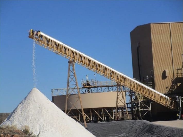 A radial stacker conveyor system depositing material onto a pile.