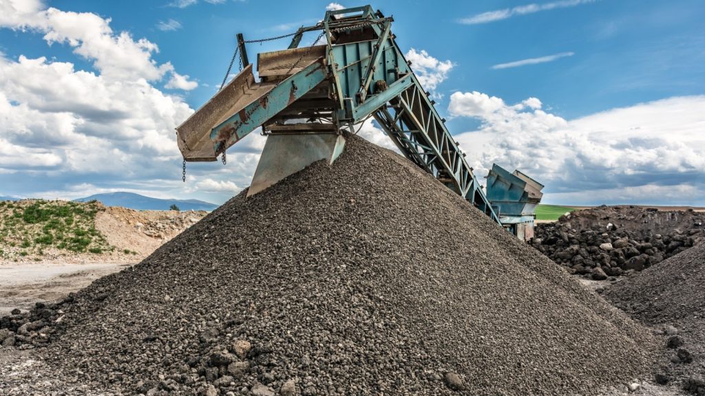 a construction conveyor moves gravel as part of a roadway development project