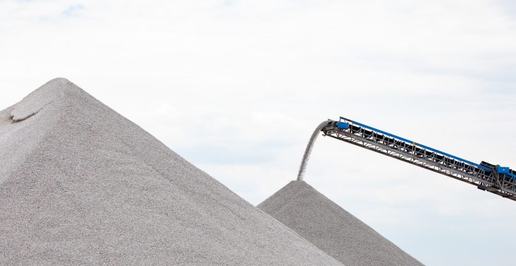 A radial stacker conveyor moves rock materials.