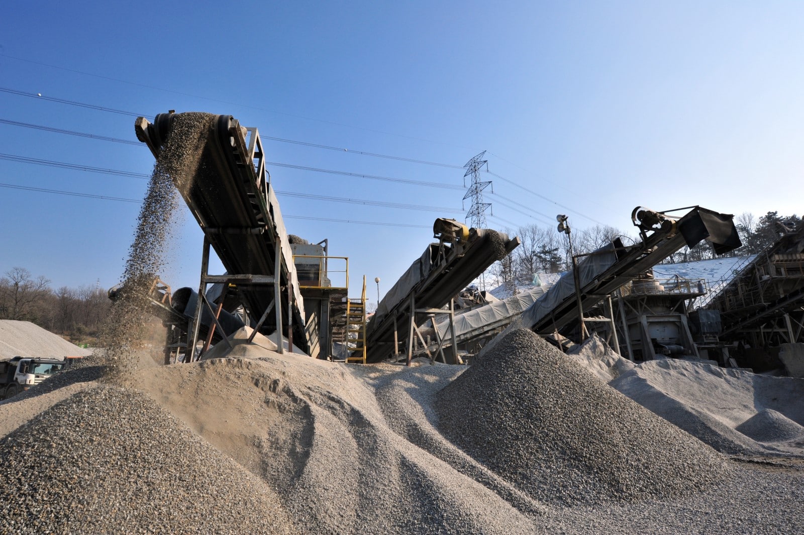 A radial stacker conveyor system depositing material onto a pile.