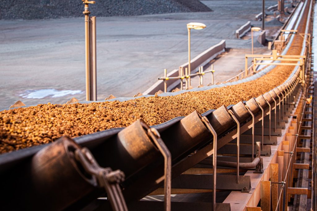 A conveyor transporting iron ore aggregate.