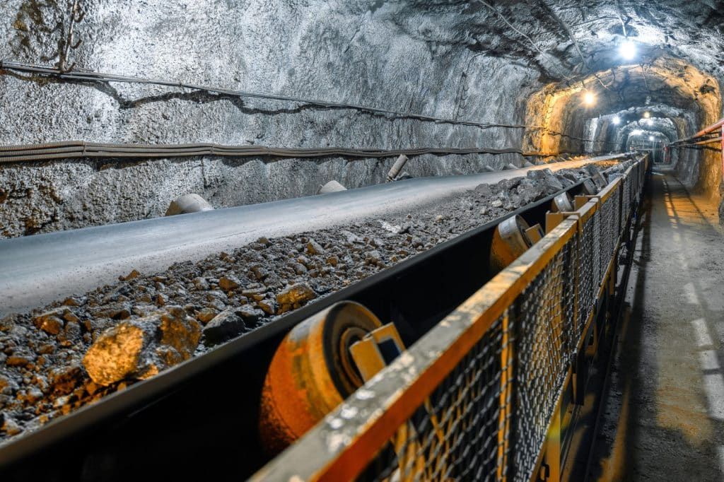 An ore mining conveyor with guarding safety feature.