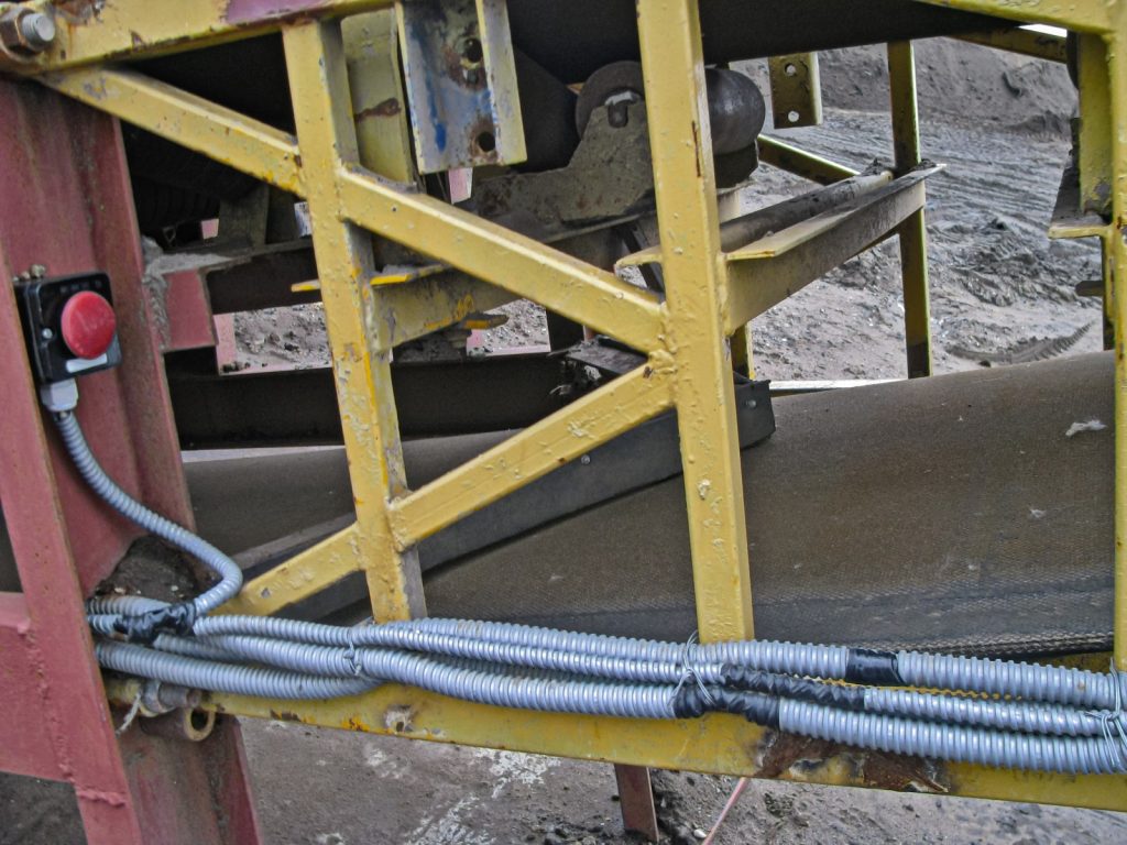 An above-ground mining conveyor emergency shutoff button.